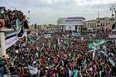 Syrians wave the national flag during a gathering in the rebel-held city of Idlib March 15, marking 10 years since nationwide anti-government protests  sparked the country's devastating civil war. (Omar Haj Kadour/AFP via Getty Images)