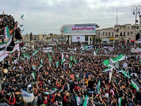 Syrians wave the national flag during a gathering in the rebel-held city of Idlib March 15, marking 10 years since nationwide anti-government protests  sparked the country's devastating civil war. (Omar Haj Kadour/AFP via Getty Images)