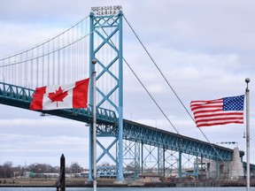 Canadian and American flags fly near the Ambassador Bridge at the Canada-U.S. border crossing in Windsor. (CP Photo)