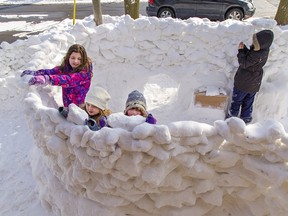 Kaida Savard, age 10 (left), her six-year-old sister Kalia and friend Riley Ferguson-Law, 6 place chunks of snow on a large snow fort encompassing the entire front yard of a Chatham Street home on Saturday February 20, 2021 in Brantford, Ontario. EDS NOTE: The child at far right could not have her name used as per the parent's request.