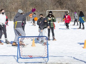 Tristan Demedeiros takes a shot during a game of snowshoe ball with his Grade 7 and 8 classmates at St. Kateri Catholic elementary school in London. Teacher Paul Murphy created the game, one of many activities teachers in the London area are doing on playgrounds with students while gyms are off limits during the COVID-19 pandemic. (Derek Ruttan/The London Free Press)