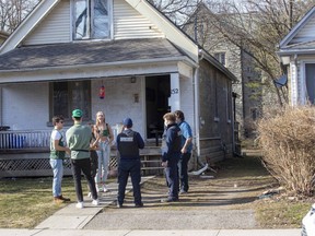 Bylaw enforcement officers speak to people on Broughdale Avenue in London on St. Patrick's Day Wednesday in an effort to control parties that could violate pandemic restrictions. (Derek Ruttan/The London Free Press)