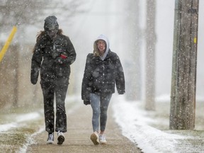 Charlotte Taylor and her roommate Jane Hallett had a cold and blustery walk home from Western university campus as they walk into a north wind and blowing snow on Richmond Street in London, Ont. (Mike Hensen/The London Free Press)
