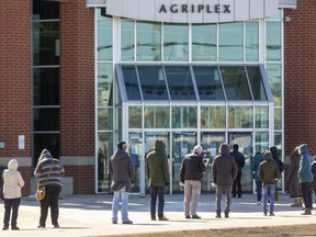 A lineup forms Thursday outside the COVID-19 vaccination site at the Western Fair District Agriplex in London. (Mike Hensen/The London Free Press)