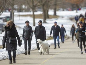 The multi-use pathways in Springbank Park were loaded with people taking advantage of the milder weather and intermittent sunshine on Sunday.  (Mike Hensen/The London Free Press)