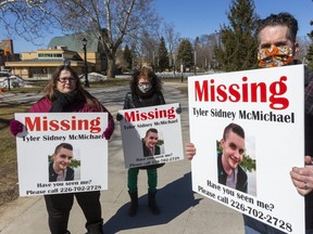 Tony McMichael, his wife Rachel, and sister Chloe McMichael hold placards in Victoria Park Sunday, March 14, 2021, to raise awareness about the disappearance of their son and nephew Tyler Sidney McMichael, who was last seen in Victoria Park two years ago.  (Mike Hensen/The London Free Press)