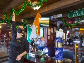 Lena Whelan of Molly Bloom's Irish pub in downtown London hangs green garlands near the bar in preparation for Wednesday's celebration of St. Patrick's Day. (Mike Hensen/The London Free Press)