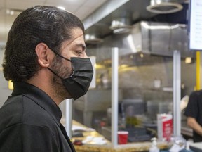 Bamyan Afghan Cuisine chef-manager Hadayat Beedar, left, talks Tuesday with a reporter while owner Nuriddin Amruddin listens in the background at the Richmond Row eatery. Beedar said the restaurant plans to apologize on social media for a racist outburst by an employee that was recorded on video and later posted on social media. (Mike Hensen/The London Free Press) (Mike Hensen/The London Free Press)