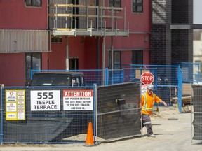 Workers at 555 Teeple  Terrace prepare to close a gate at the construction site on Thursday. The apartments are being advertised for rent by September.  (Mike Hensen/The London Free Press)