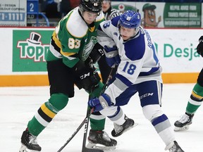 Owen Robinson, right, of the Sudbury Wolves and Hunter Skinner of the London Knights battle for the puck during OHL action at the Sudbury Community Arena on Friday December 20, 2019.