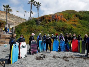 A senior women's group gather for a morning boogie boarding session in the ocean waves on International Women's Day, amid the outbreak of the coronavirus disease (COVID-19) in Solana Beach, California, U.S., March 8, 2021.  REUTERS/Mike Blake ORG XMIT: FW1