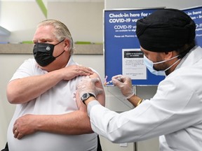 Ontario Premier Doug Ford receives the Astrazeneca-Oxford coronavirus disease (COVID-19) vaccine  from pharmacist Anmol Soor at Shoppers Drug Mart in Toronto, Ontario, Canada April 9, 2021.  Nathan Denette/Pool via REUTERS