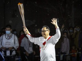 Toyota president Akio Toyoda joins the Olympic torch relay last week. The relay, choreographed to symbolize recovery, looks more and more like baffling obstinacy amid the global pandemic, columnist Robin Baranyai writes.