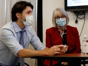Prime Minister Justin Trudeau, with Health Minister Patty Hajdu, holds an empty COVID-19 vaccine vial after the first vaccinations were given at the Civic Hospital in Ottawa in December. Columnist Lorrie Goldstein says the federal government's failure to deliver enough vaccines is to blame for Canada's low vaccination rates.