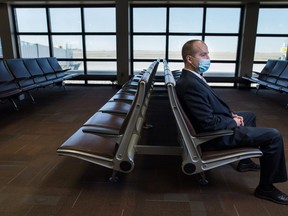 James Bogusz strikes a solitary profile sitting alone in an empty passenger lounge at the Regina International Airport, where he’s the chief executive. Bogusz says the airport can get by with fewer passengers than before the pandemic, “but I can’t make it work with 10 per cent.” (BRANDON HARDER/ Regina Leader-Post)