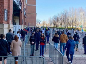 People line up at M&T Bank Stadium in Baltimore, Maryland, which was transformed in a COVID-19 mass vaccination site on March 20, 2021. (Photo by Eric BARADAT / AFP)