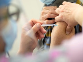 A senior receives the vaccine against the coronavirus disease (COVID-19) as Quebec begins vaccinations for seniors over 85 years old in a clinic in Laval, Quebec.