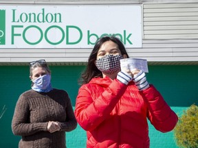 Cadence Lankin, 17, raised $1,100 for the London Food Bank by raffling off four of her paintings. Accepting her donation on Friday is food bank co-executive director Jane Roy. (Derek Ruttan/The London Free Press)