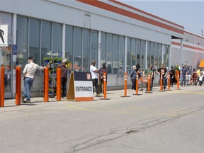 Customers line up Wednesday afternoon at the Home Depot store at Southdale and Wonderland roads to stock up before an anticipated stay-at-home order from the province went into effect. (Derek Ruttan/The London Free Press)