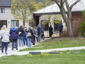 People line up at the COVID-19 vaccination clinic at the Caradoc Community Centre in Mt. Brydges on Monday. Next week, the Middlesex-London Health Unit will see its vaccine deliveries cut by 25 per cent to steer more to virus hot spots in the province. (Derek Ruttan/The London Free Press)