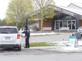 People receive information as they enter the parking lot of the COVID-19 vaccination clinic at the Caradoc Community Centre in Mt. Brydges on Wednesday April 21, 2021. (Derek Ruttan/The London Free Press)