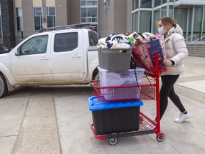 Western student Daniela Pavela rolls belongings to her mother's vehicle Thursday as part of a "pre-move" before heading home to Georgetown at month's end. Western has asked residence dwellers to move home and shifting classes and exams online to battle aggressive COVID-19 variants gaining a toehold on campus. (Mike Hensen/The London Free Press)
