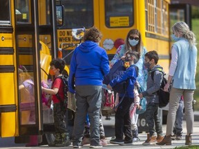 Students get on their school buses at Eagle Heights public school in London on Wednesday April 7, 2021. (Mike Hensen/The London Free Press)
