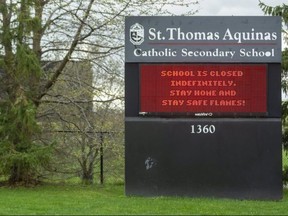 The sign for St. Thomas Aquinas Catholic secondary school had a stark message Monday after the province announced schools will switch to online learning after the spring break. (Mike Hensen/The London Free Press)