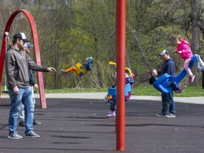 Parents were out in numbers with their children on the swings in Springbank Park in London on Sunday. On Saturday, the province reversed its decision to close playgrounds to prevent the spread of COVID-19.  
Photograph taken Sunday April 18, 2021.  (Mike Hensen/The London Free Press)