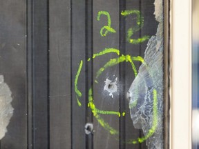 Four bullets are marked off in the front door of a townhouse unit at 2000 Wavell Street in London's east end. (Mike Hensen/The London Free Press)