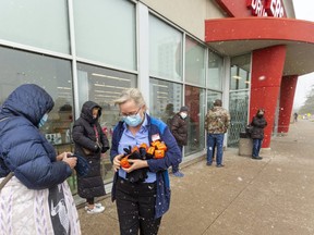 People line up outside the Shoppers Drug Mart at Wonderland and Fanshawe Park roads to get COVID-19 vaccine shots in late April. (Mike Hensen/The London Free Press)