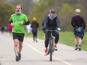 Chad Wyant of London, who has run the half-marathon at the Forest City Road Races "nearly every year," runs through Greenway Park with Leslie Prentice alongside as a "pace partner," Prentice said. All this year's races were virtual, with runners completing their distances across the city. Photo taken Sunday April 25, 2021. (Mike Hensen/The London Free Press)