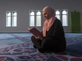 Sahar Zimmo, a volunteer at the London Muslim Mosque, reads the Qur'an in the mosque where Zimmo is organizing a large online event for Friday to break the day's Ramadan fast. The general public is invited to join in the celebration. (Mike Hensen/The London Free Press)