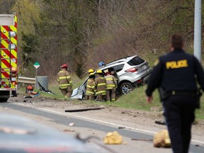 Firefighters free two people from an SUV after it crashed into a trailer pulling a boat on Oil Heritage Road near Discovery Line in Petrolia on Friday. (Terry Bridge/Postmedia Network)