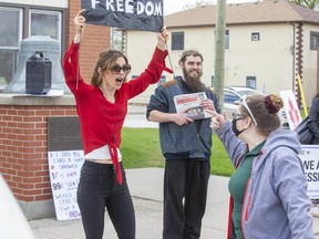 Robin Collison (right) has a heated exchange with lockdown protester Danielle Debock outside of the post office in Glencoe, on Friday May 7, 2021. Fifteen people protested outside of the post office. Debock was denied service at the post office last week for not wearing a mask. (Derek Ruttan/The London Free Press)