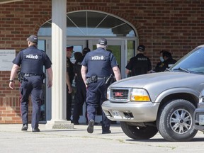 Police enter the Church of God on Friday to change door locks and enforce a court order to close the Aylmer church. (Derek Ruttan/The London Free Press)