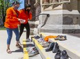 Tammy Doxtator and her daughter, Joelle Mandamin, place tiny shoes on the steps of St. Peter's Cathedral Basilica in London in memory of 215 children whose remains were found recently on the grounds of a former residential school in Kamloops, B.C. Doxtator's father was a residential school survivor. (Mike Hensen/The London Free Press)