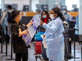 Healthcare workers hand out face shields as they prepare to test passengers as they arrive at Toronto's Pearson airport after mandatory coronavirus disease (COVID-19) testing took effect for international arrivals February 15, 2021.