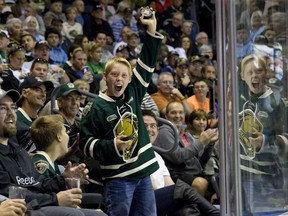 London Knights fan Noel Melady, 12, celebrates after catching a wayward puck during their OHL regular season hockey home opener against the Plymouth Whalers at Budweiser Gardens in London on Friday September 26, 2014.  Craig Glover/London Free Press