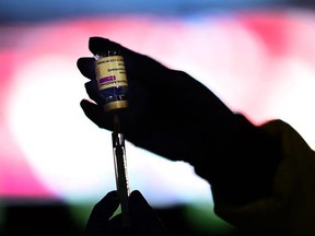 In this file photo a health worker prepares a dose of the AstraZeneca/Oxford vaccine at a coronavirus vaccination centre at at the Wanda Metropolitano stadium in Madrid on March 24, 2021.