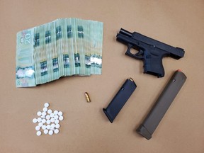 Police seized a Glock 9mm handgun, 10 rounds of ammunition, a prohibited 30-round magazine, Oxycodone tablets and about $10,000 in cash in a raid on a Colborne Street home in downtown London Sunday. Two men are charged. (Police photo)