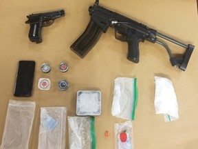 London police released this image of replica guns, drugs and other items seized in searches of two city homes Thursday. Two men face drug trafficking charges. (Supplied)