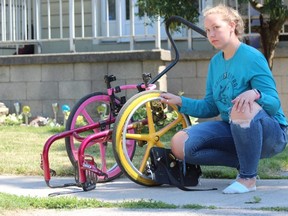 Haley Fair, 21, holds her nine-year-old sister's damaged wheelchair outside of the family's east London home on Wednesday. Police returned the custom-made wheelchair after recovering it during an arrest, but it has been damaged and is no longer usable, Fair said. DALE CARRUTHERS / THE LONDON FREE PRESS