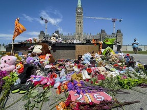 Residential schools memorial of shoes at the Centennial Flame on Parliament Hill , in memory of the 215 children whose remains were found on the grounds of the former Kamloops Indian Residential School in Kamloops, B.C. (Errol McGihon/ Postmedia)