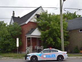 A London police cruiser remains parked outside a house at 254 Hamilton Rd. in London on the morning of June 22, 2021. Hours earlier, fire tore through the home. (Calvi Leon/The London Free Press)