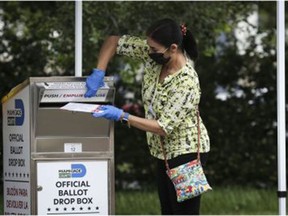 An election official puts a mail-in ballot in a drop box at an early polling place for the 2020 presidential election in Miami last fall. Republicans, unhappy with their 2020 election loss, continue to seek ways to undermine the result.