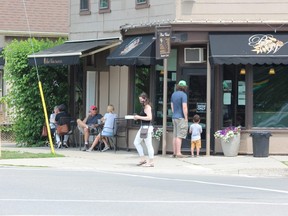 People sit on the outdoor patio at the Black Walnut cafe in Wortley Village Sunday. Bar and restaurant patio service resumed 
Friday as Ontario began easing pandemic restrictions under Step 1 of its economic reopening plan. (Dale Carruthers/The London Free Press)