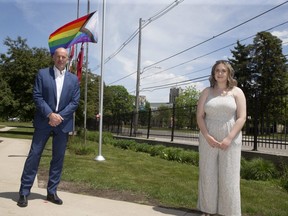 David Malloy, principal of King's University College, left, and King's student council president Holly Clarke stand in front of the Progress Pride flag that was raised Tuesday. Flags at the college are flying at half-staff for 215 hours to honour the 215 Indigenous children whose remains were recently discovered at a former residential school in Kamloops, B.C. (Derek Ruttan/The London Free Press)