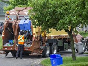 Rodney Lupo empties blue boxes into a Miller Waste Systems truck in London. (Derek Ruttan/The London Free Press)