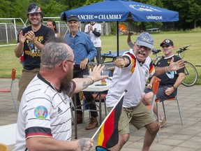 Jerry Ziler, left, and Juergen Belle, president of London’s German Canadian Club, safely celebrate a goal as Germany tied Hungary 2-2 Wednesday to meet England in the last 16 at Euro 2020. (Derek Ruttan/The London Free Press)